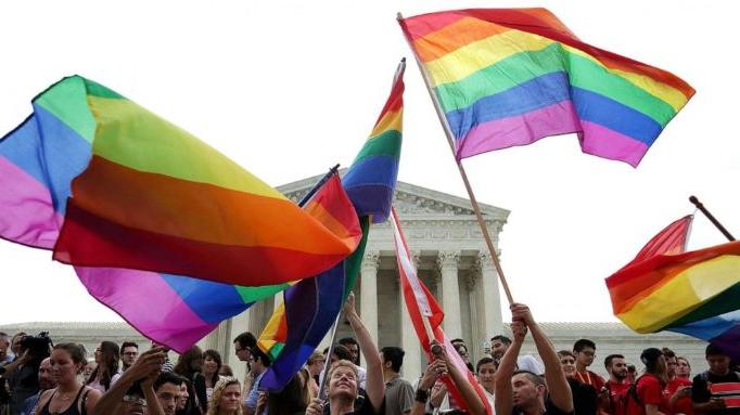 同性恋旗帜在人群和最高法院的背景下升起